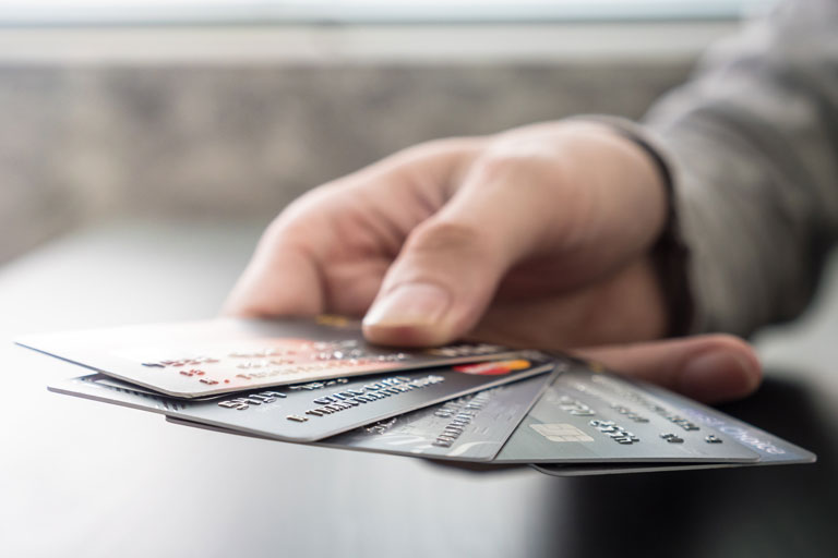 Male hands holding 5 different credit cards