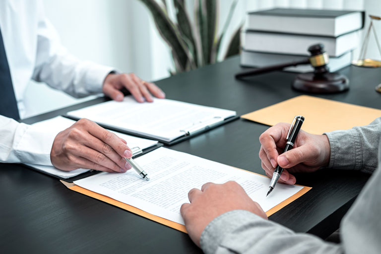 Male lawyer showing his client where to sign paperwork