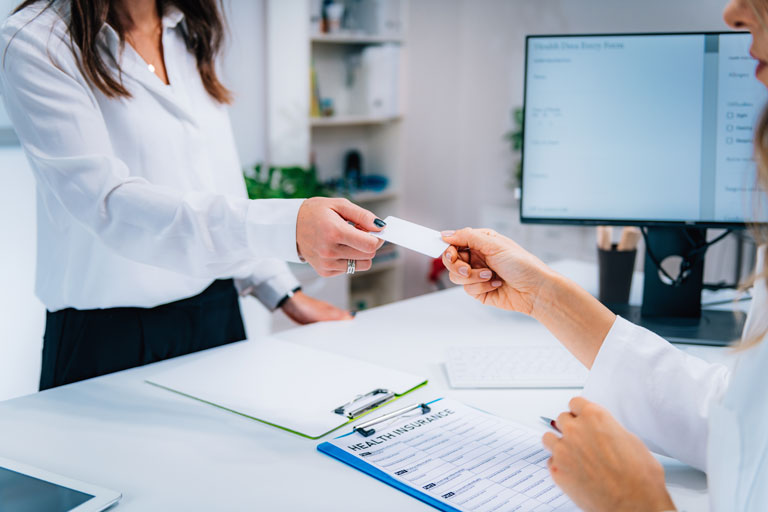 Woman paying for a medical procedure with a credit card at a healthcare facility