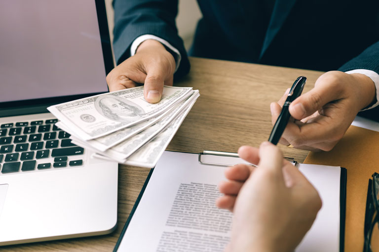 Loan officer handing out cash and a pen to a customer