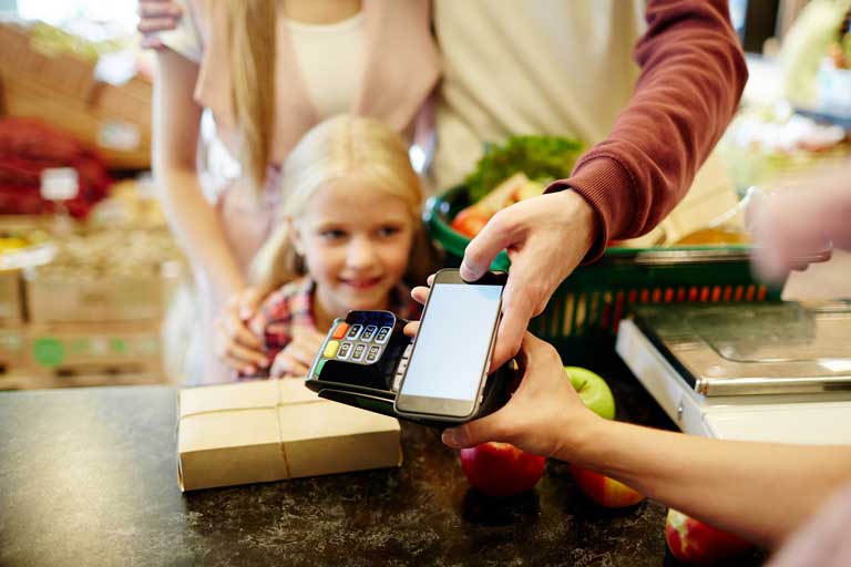 Family paying for groceries with a smartphone at a supermarket