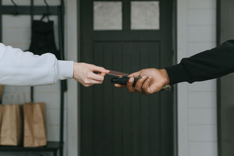 Woman paying for a delivery with a credit card