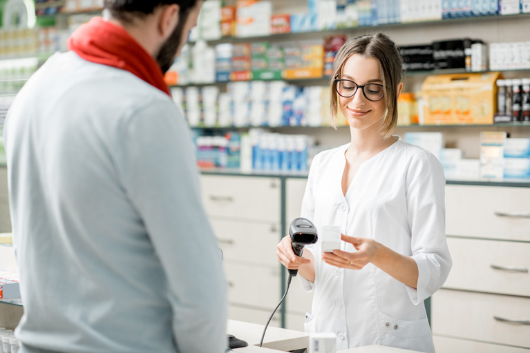 Pharmacist scanning medicine for a customer