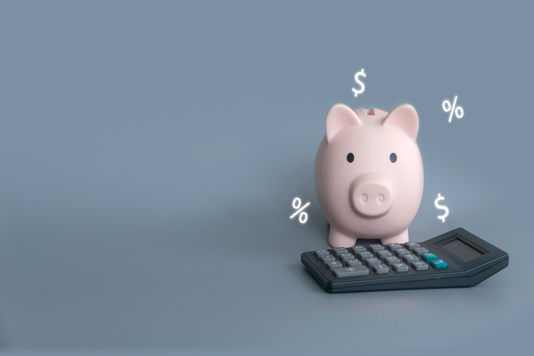 Piggy bank and calculator with percentage and currency signs