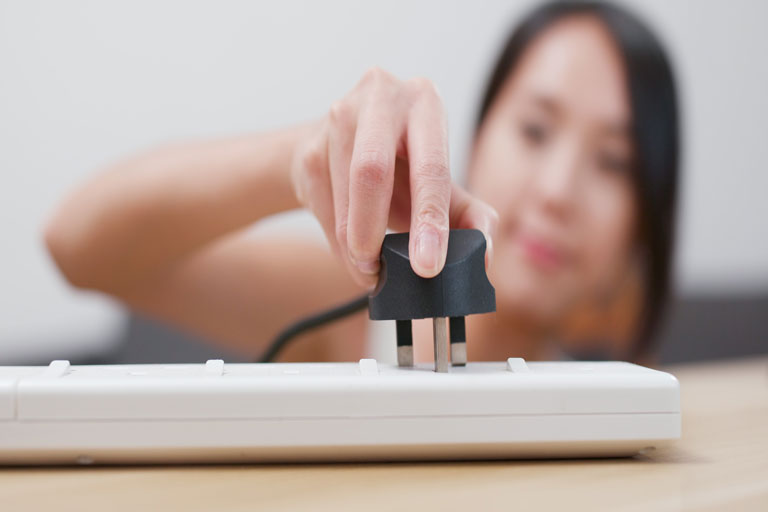 Woman plugging in a power cord