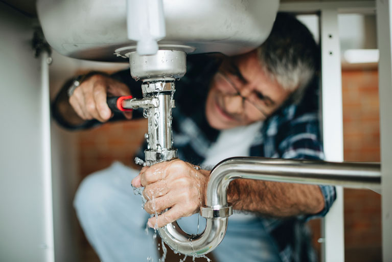 Plumber fixing a leaking sink