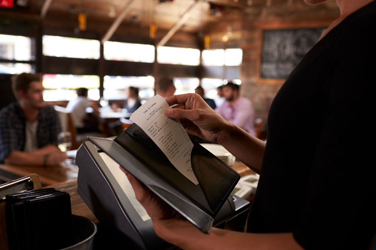 Waitress preparing the bill at a restaurant for it to be taken to the table