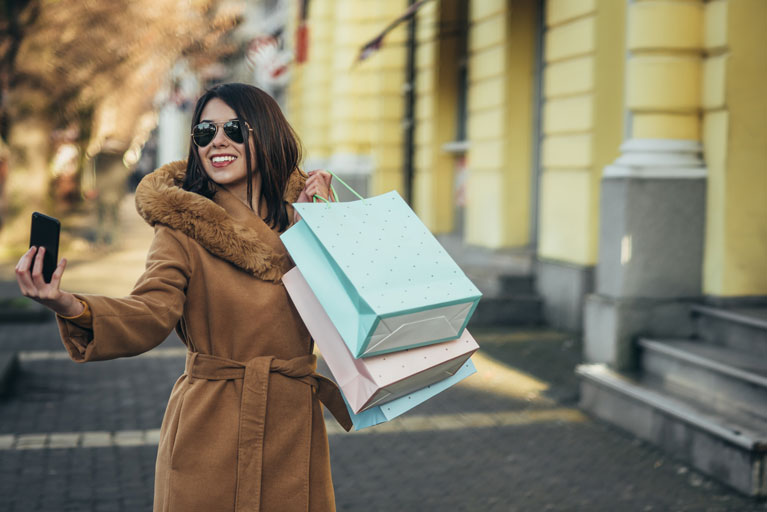 Woman with shopping bags taking a selfie