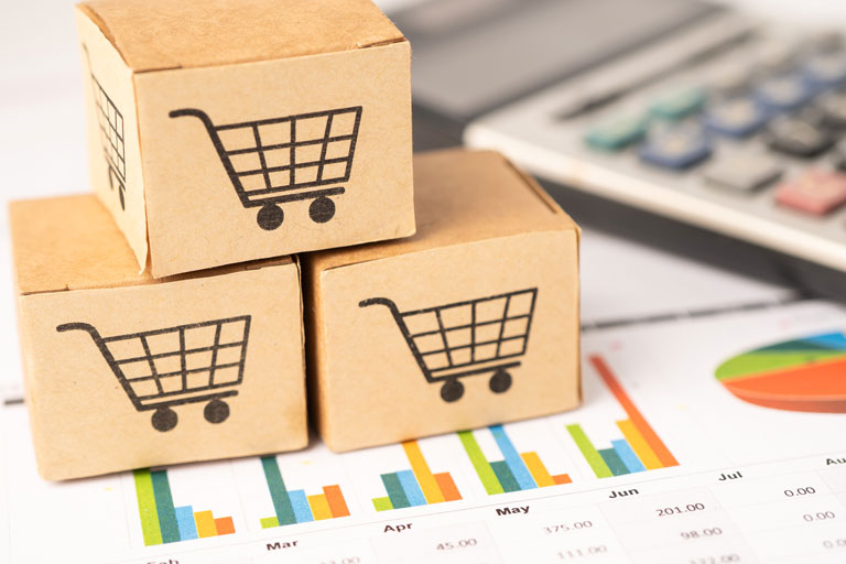 Small cardboard boxes with shopping carts printed on top of a sales analysis