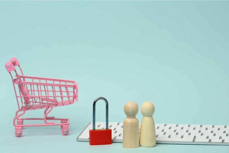 A small pink shopping cart, red padlock, two wooden shapes and a keyboard in a blue room