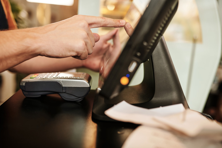 Cashier pressing a touchscreen inside a restaurant