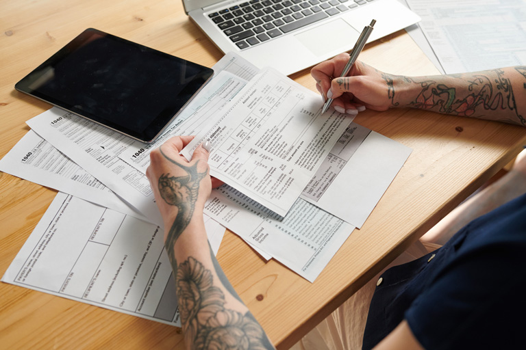 Tattooed woman filling out tax forms