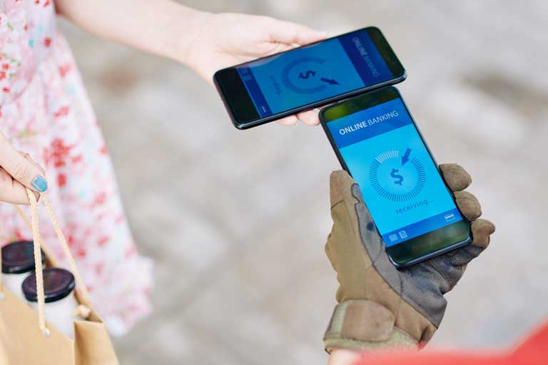 Woman transferring money with her phone to a delivery driver for her food