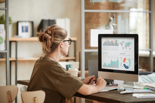 Woman working at a computer and looking at graphs